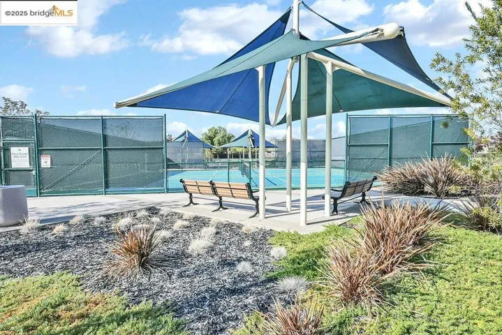 View of pool with a tennis court