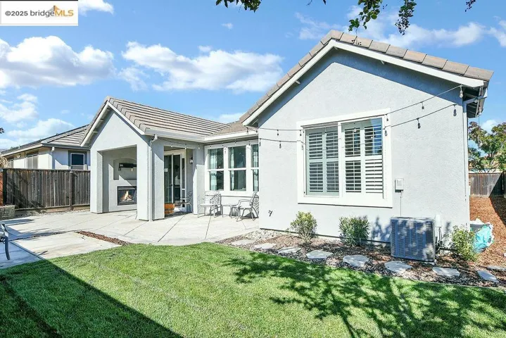 Rear view of property featuring a patio, stucco siding, and a tile roof