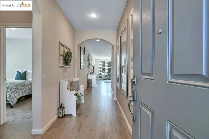 Entryway featuring arched walkways, light wood-style floors, and recessed lighting