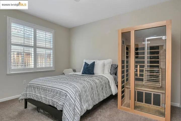 Carpeted bedroom featuring a sauna / steam room and baseboards