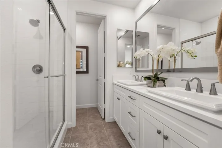 Walk-in shower, dual sink and privacy toilet in the primary bathroom