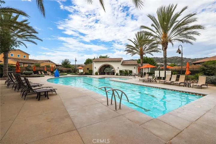 Inviting swimming pool area with plenty of seating and sunny weather.