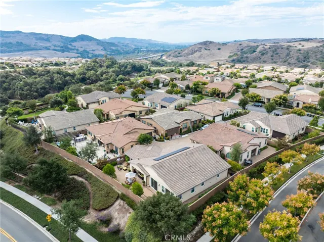Expansive neighborhood aerial view with mountain backdrop and clear skies.