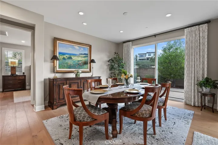 Formal dining area with a large table and natural light streaming through windows.