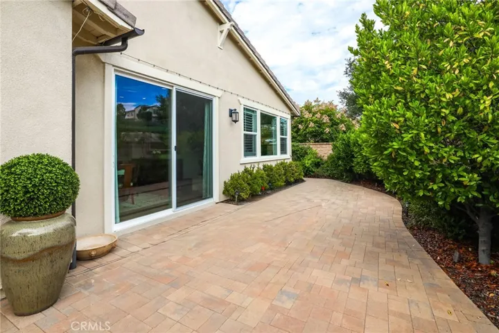 Side yard pathway bordered by lush shrubs and mature landscaping.