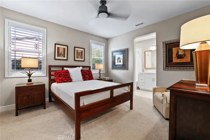 Spacious bedroom featuring ceiling fan, wood floors, and neutral tones.