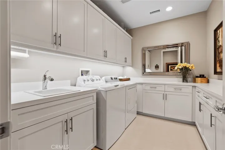 Large laundry room with built-in cabinets and countertops for convenience!