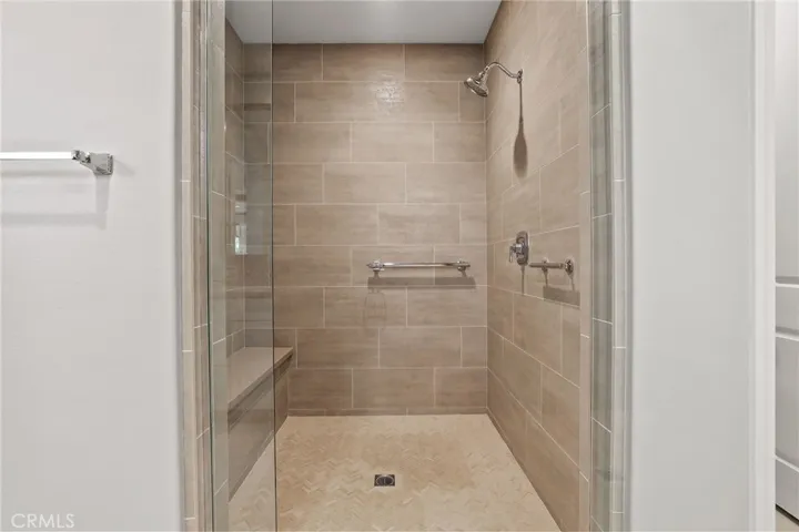 Modern walk-in shower with sleek tile and glass enclosure.