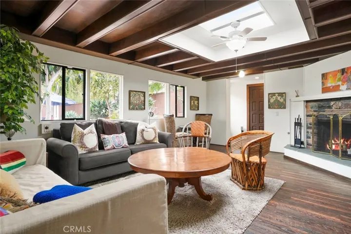 Main house guest wing living room.  Private access, fireplace, wood beam ceiling and views of both the pool and atrium.