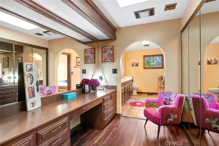 The primary suite bathroom with 2 separate spaces.  This side features a large walk-in closet, built in drawers, and dressing area.