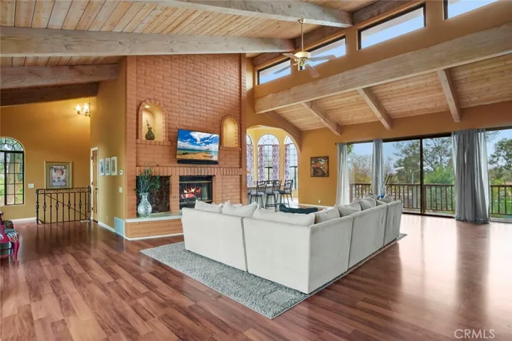 The guest house living room enjoys vaulted wood beam ceilings and an abundance of natural light.  View decks on both sides.  Wood burning fireplace.
