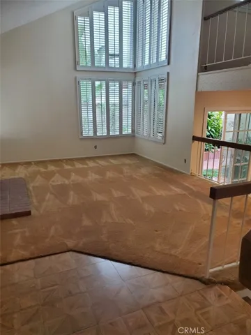 Living room with vaulted ceiling and hardwood entry