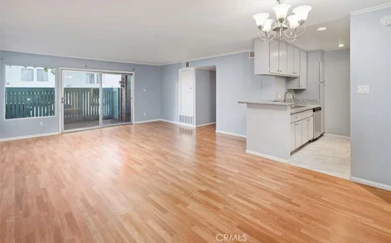 Living room with dining area and kitchen overlooking patio