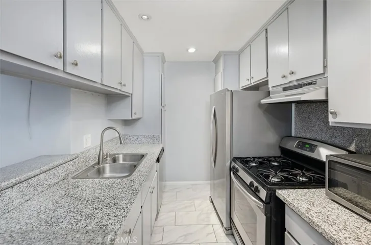 Galley kitchen with granit countertops and stainless steel appliances