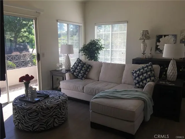 Spacious Living Room with high ceilings, cozy fireplace, and sliding glass door to balcony