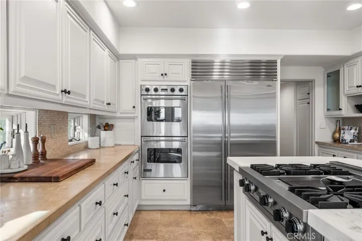 Kitchen-Well Appointed Replete with Stainless Steel Viking Rangetop, Double Oven and Microwave Oven, Subzero Fridge/Freezer and Full Size Wine Fridge, Espresso/Coffee Machine, Trash Compactor, Toaster Oven, and Walk-In Pantry on the right