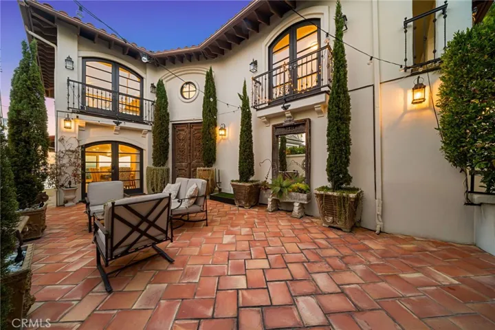 Courtyard Foyer-Main-2nd Level from Street/From Italy 1,000 Year Old 8' Ornate Carved Double Wooden Front Doors & Full Size Mirror/Mediterranean Landscape & Cypress Trees/Outdoor Seating/Classic Spanish Tile-Seamless Indoor/Outdoor Experience w/Formal Dining Room & Main Entrance Foyer/Quintessential Old World Essence Carried Throughout Estate/String & Lantern Lights/View West at Sunset