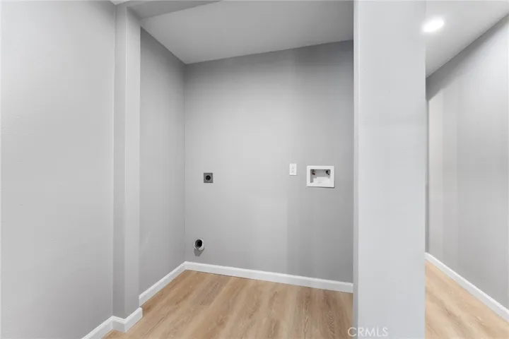 Laundry (electric hookup) in the hallway near the two bedrooms. Hallway leads to the full bathroom and the living areas.