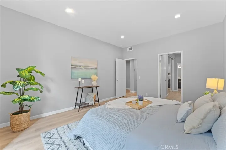 Spacious primary bedroom with high ceilings, newly installed luxury vinyl plank flooring, newly painted, recessed lighting.
