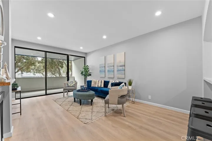 Newly installed luxury vinyl plank flooring, recessed lighting, newly painted, 9' ceilings. Fireplace to the left of image. Sliders to a patio that is roomy enough for a BBQ and seating.