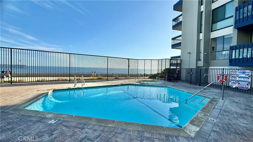 Pool and hot tub with view of the ocean.