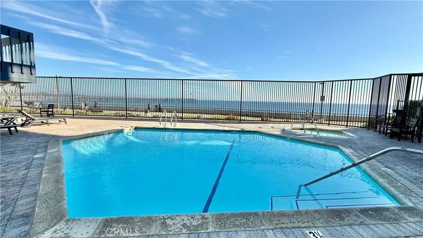 Pool and hot tub with view of the ocean.