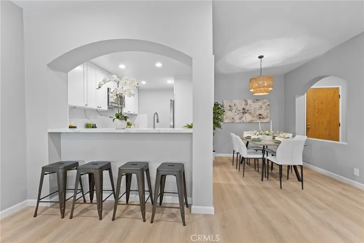 Room to dine casually at passthrough to kitchen. Newly installed luxury vinyl plank flooring, newly painted, new light fixture, new recessed lighting, updated kitchen. 9' ceilings.