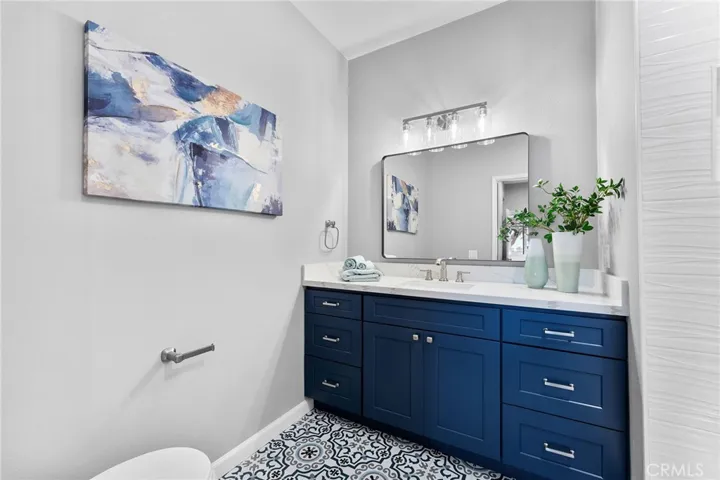 Primary en suite with custom tile flooring to compliment the cabinets with soft closed features. New lighting, new mirror, quart counters, new commode. All new for you.