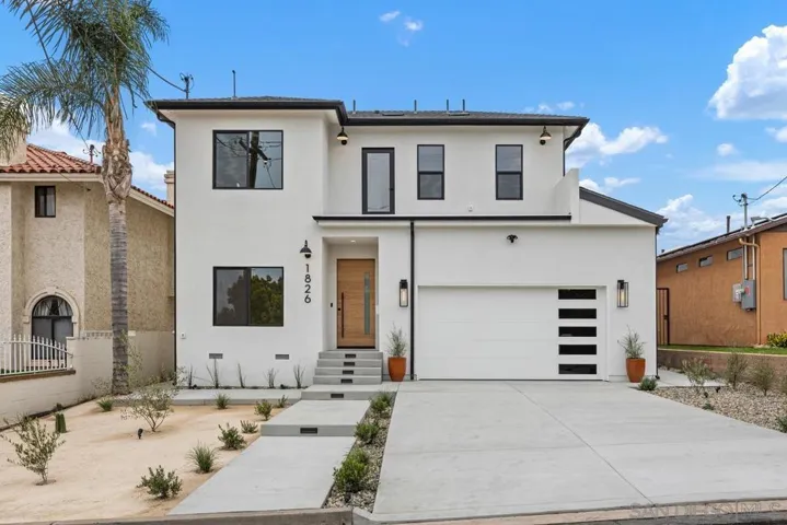 Entrance to house with driveway and two car garage