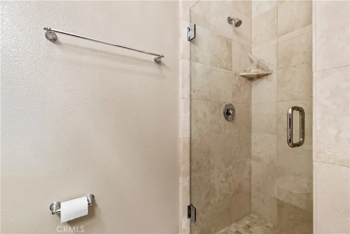 Walk in shower with neutral tile.