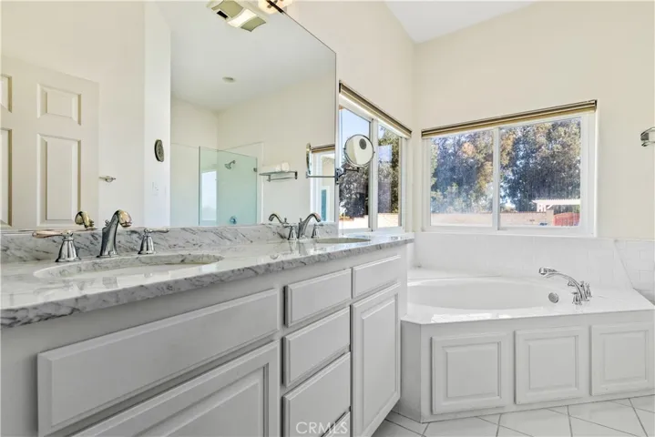 Spacious primary bathroom with soaking tub and dual sink vanities.