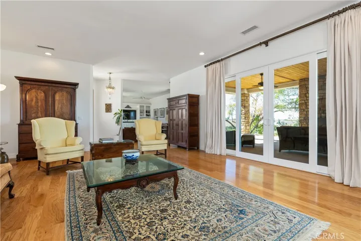 Expansive living room with sliding doors to a covered patio overlooking the olive orchard and golden hills.