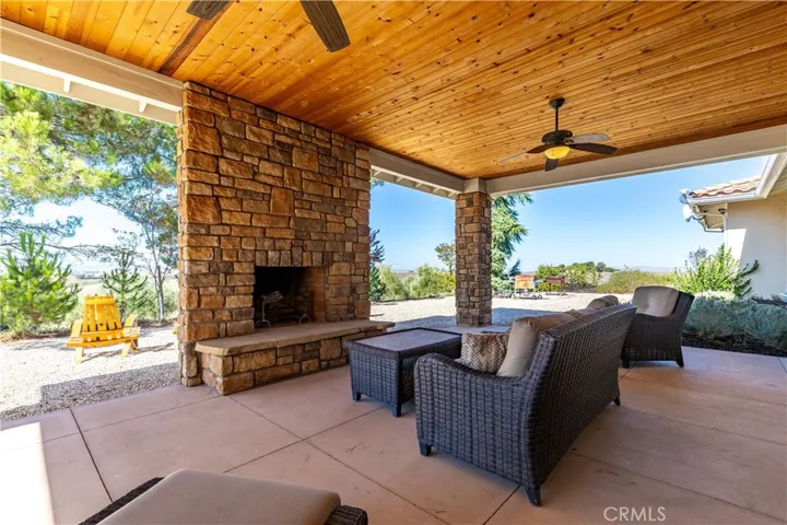 Another perspective of the covered patio with a beautiful outdoor fireplace.