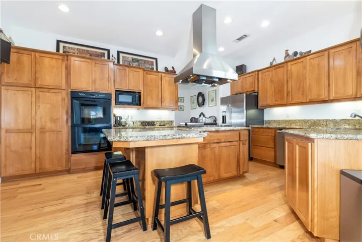 Kitchen features ample cabinetry, granite countertops, and bar seating for convenience at the island.