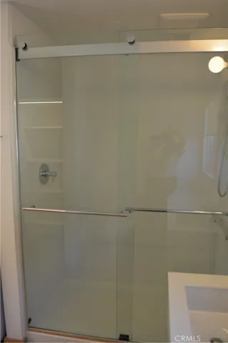 Full sized shower with glass doors.