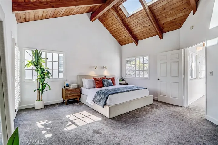 Primary bedroom with high ceilings and skylights.