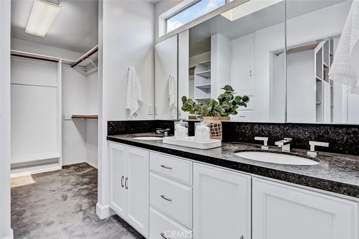 Primary bath with double sinks and large walk-in closet.