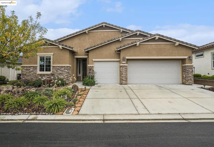 Craftsman-style house featuring stone siding, stucco siding, and driveway