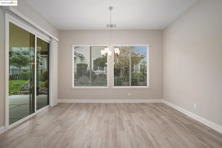 Unfurnished dining area featuring light wood-type flooring and a chandelier
