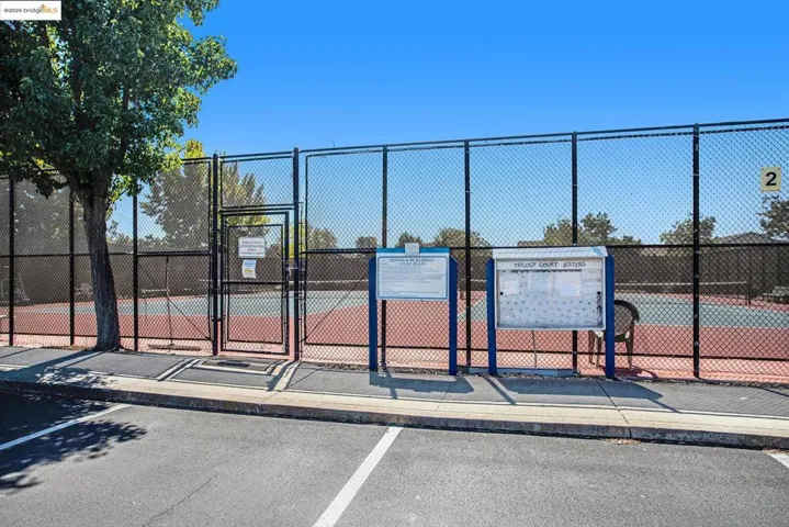 View of tennis court with a gate