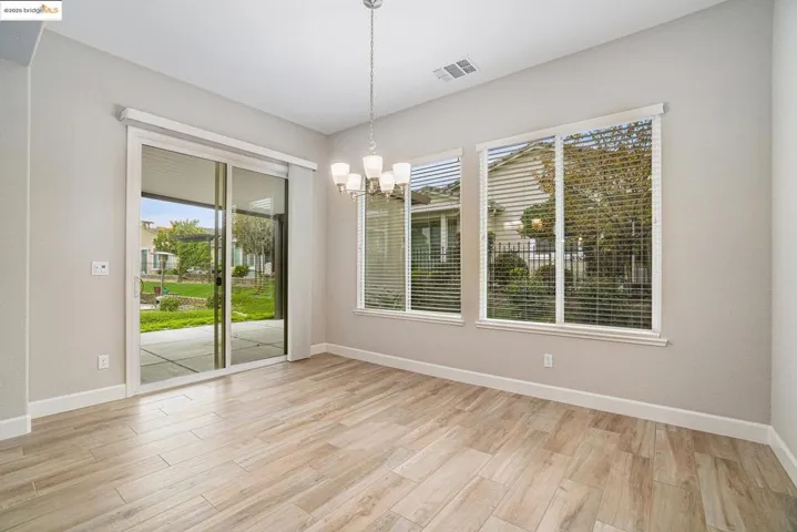 Unfurnished dining area featuring light wood finished floors and a chandelier