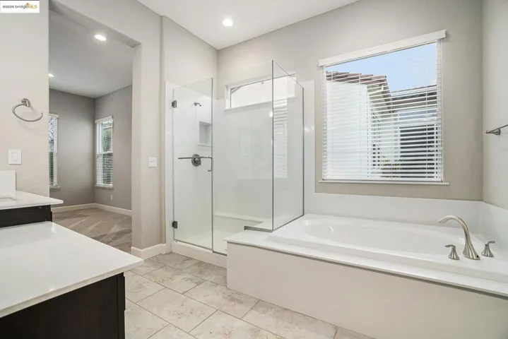 Bathroom with vanity, a garden tub, a stall shower, light tile patterned floors, and recessed lighting