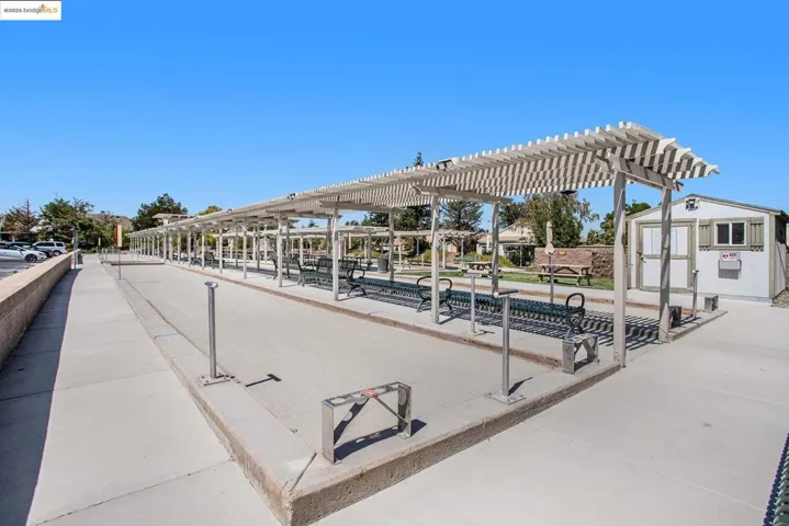 Surrounding community featuring a game area, a storage unit, and a pergola