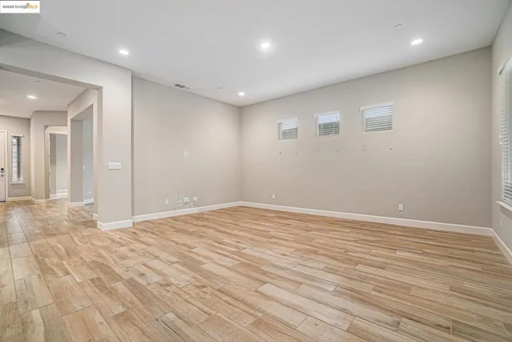 Empty room featuring light wood finished floors and recessed lighting