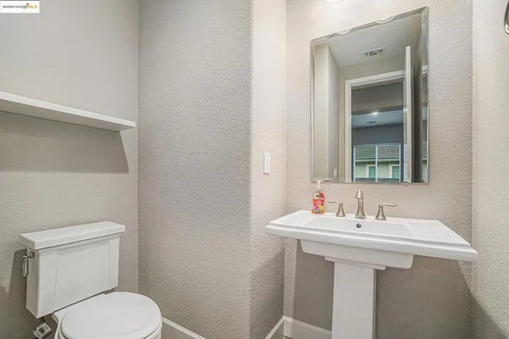 Half bath featuring a textured wall