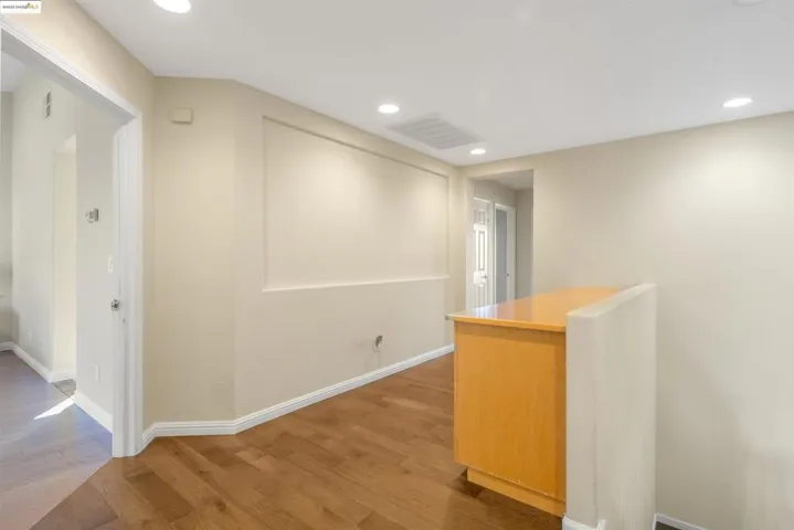 Hall with recessed lighting and wood finished floors
