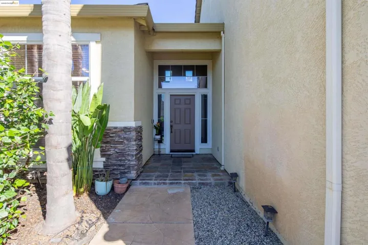Entrance to property featuring stucco siding and stone siding