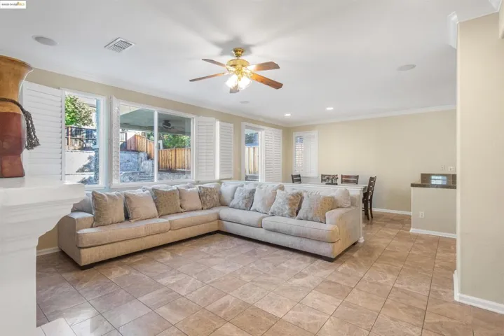 Living area with crown molding, ceiling fan, and recessed lighting