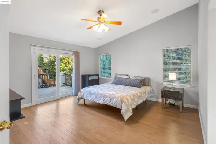 Bedroom featuring lofted ceiling, access to outside, light wood finished floors, and ceiling fan