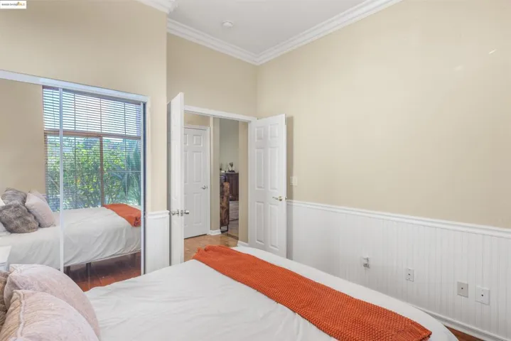 Bedroom with ornamental molding and wainscoting